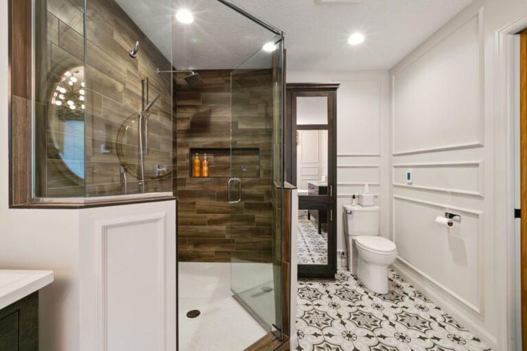 Modern bathroom with walk-in shower, white vanity, marble tile flooring, and glass enclosure