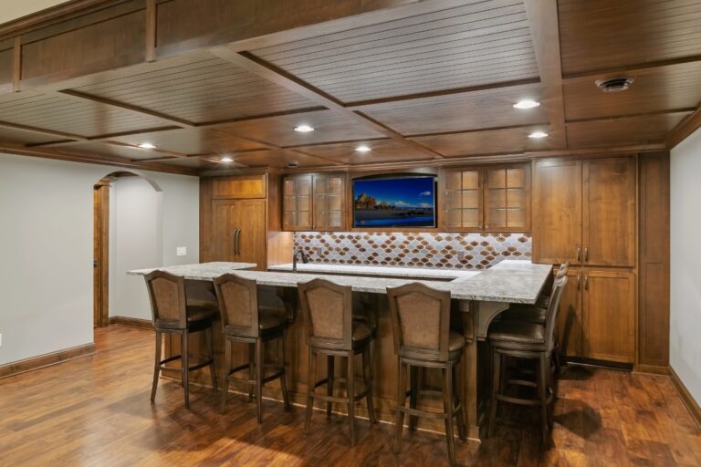Wood-paneled recreation room with foosball table, bar seating, and recessed lighting in ceiling