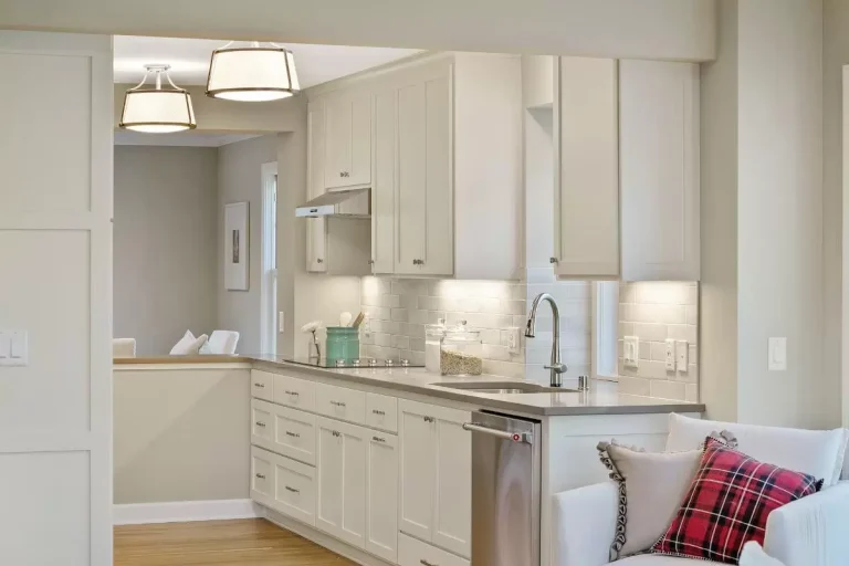 Modern kitchen with white cabinetry, stainless steel appliances, granite countertop, and decorative throw pillow