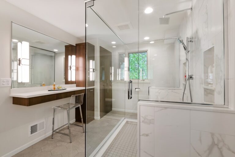 Modern bathroom with floating vanity, walk-in shower, marble tile flooring, and large mirror