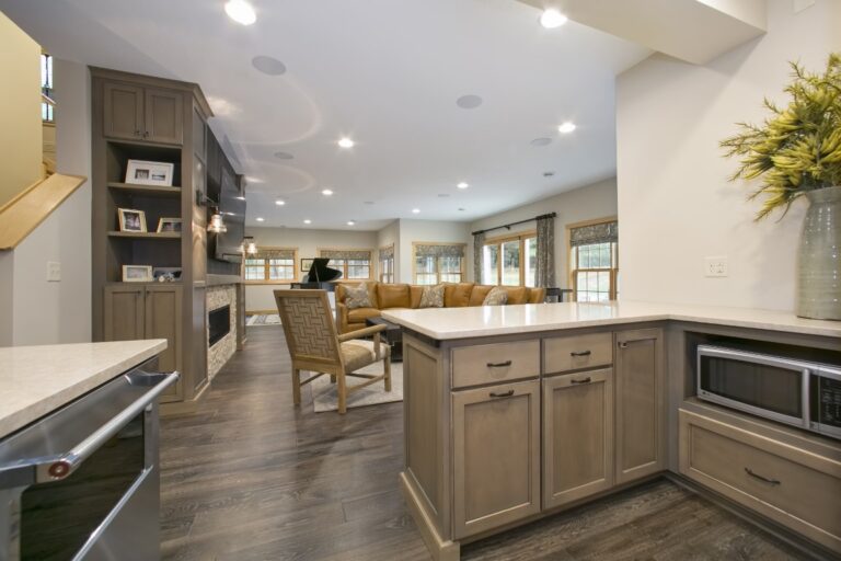 Modern kitchen with wooden cabinetry, island, stainless steel appliances, and open floor plan leading to dining area