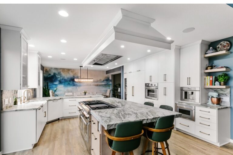 Modern kitchen with white cabinetry, marble island, stainless steel appliances, and green bar stools