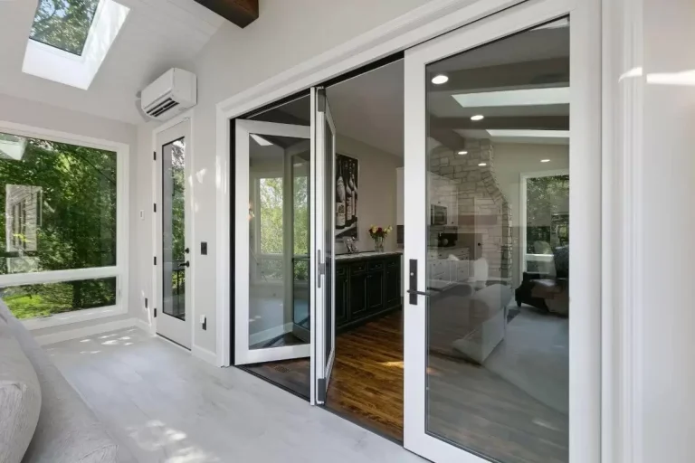 Modern bathroom with glass shower enclosure and sliding glass doors opening to outdoor area with green landscape