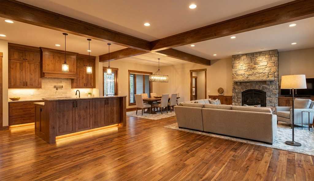 Open concept kitchen dining and living room with defined zones using lighting and furniture arrangement